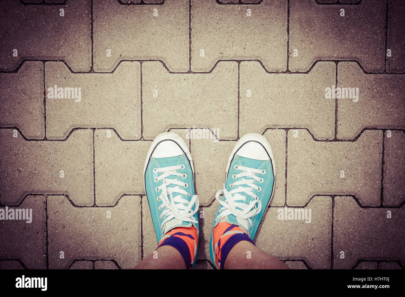 On a walk wearing sneakers, top view on concrete pavement and blue
