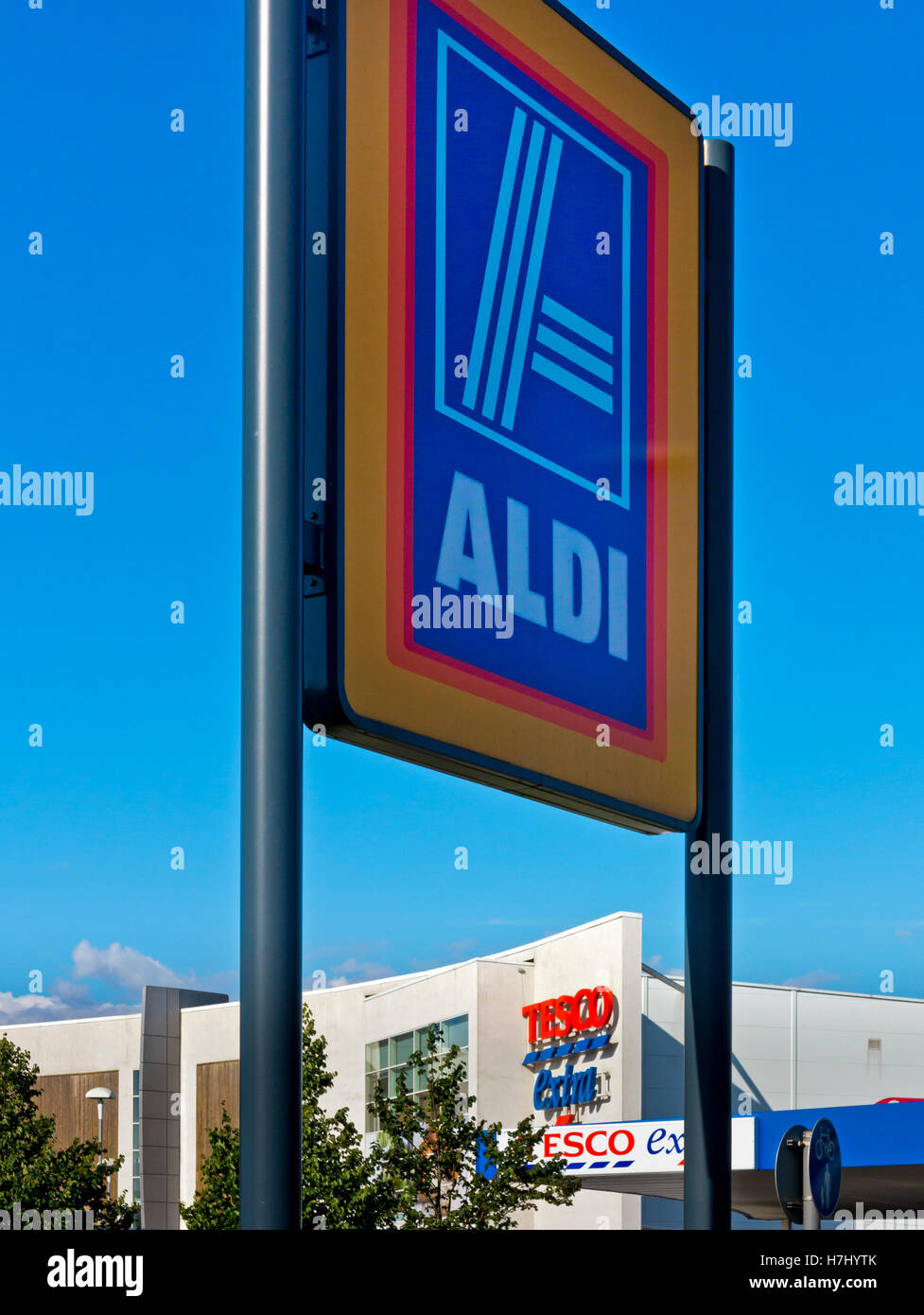Aldi supermarket sign with Tesco Extra supermarket in background in