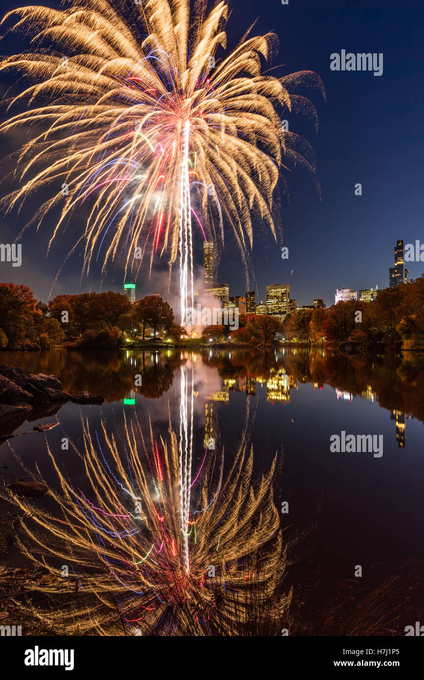 Central Park Fireworks celebrating the Marathon reflecting on the Lake. Midtown Manhattan, New York City Stock Photo