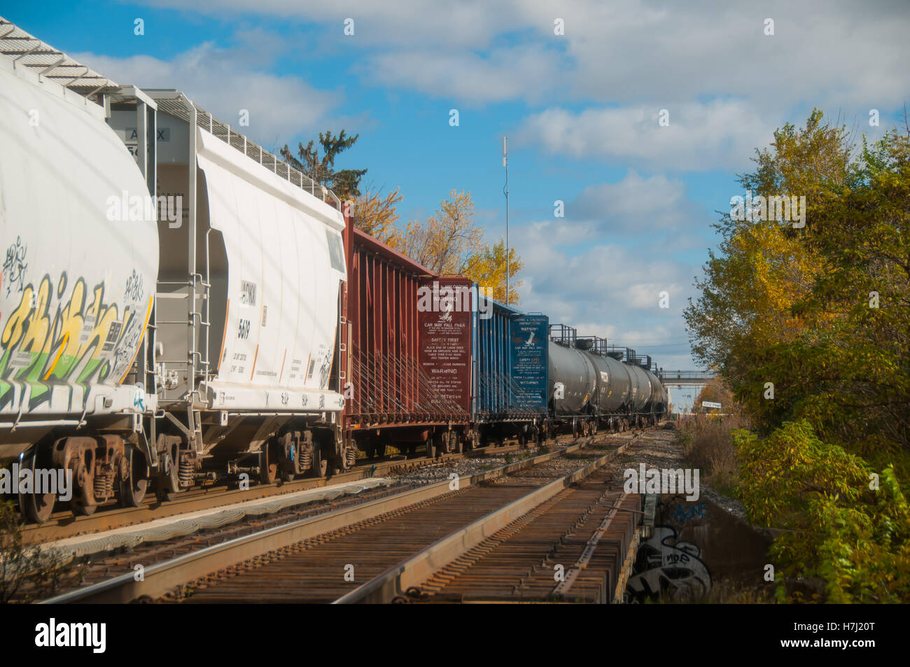 Freight train crossing an old wood bridge in autumn. Stock Photo