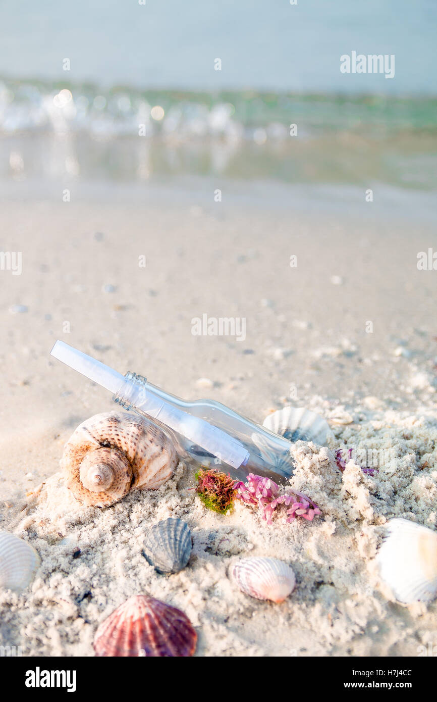 Bottle with a message or letter on the beach near seashell. SOS Stock ...