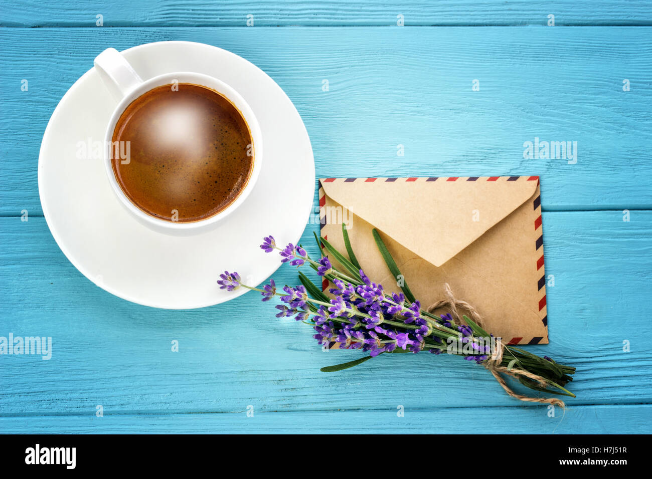 blank white notebook,envelope, bunch of lavender and cup of coffee on the desk Stock Photo