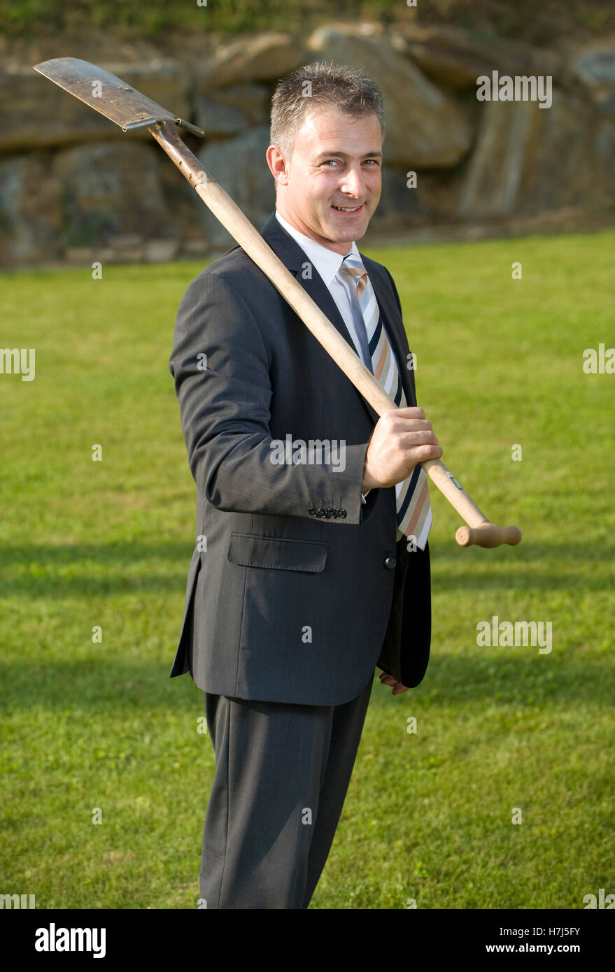 Successfully businessman holding a spade Stock Photo