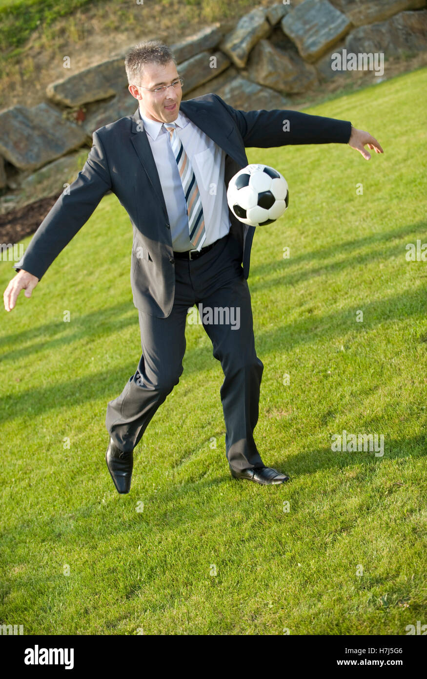Businessman with a soccer ball in a park Stock Photo - Alamy