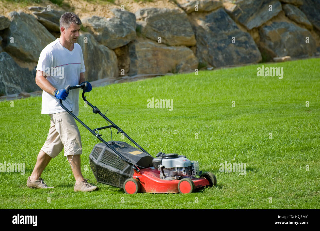 Man mowing the lawn Stock Photo
