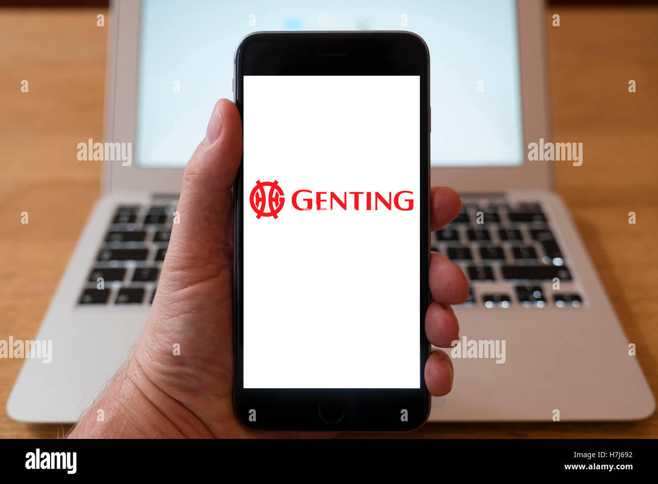 Using iPhone smart phone to display logo of Genting Malaysian conglomerate, operator of casinos and resorts. Stock Photo