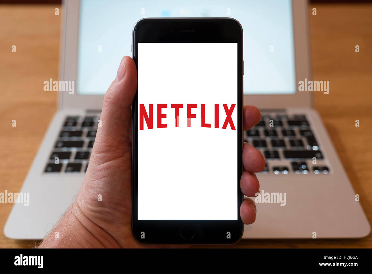 Using iPhone smartphone to display logo of Netflix movie streaming service Stock Photo
