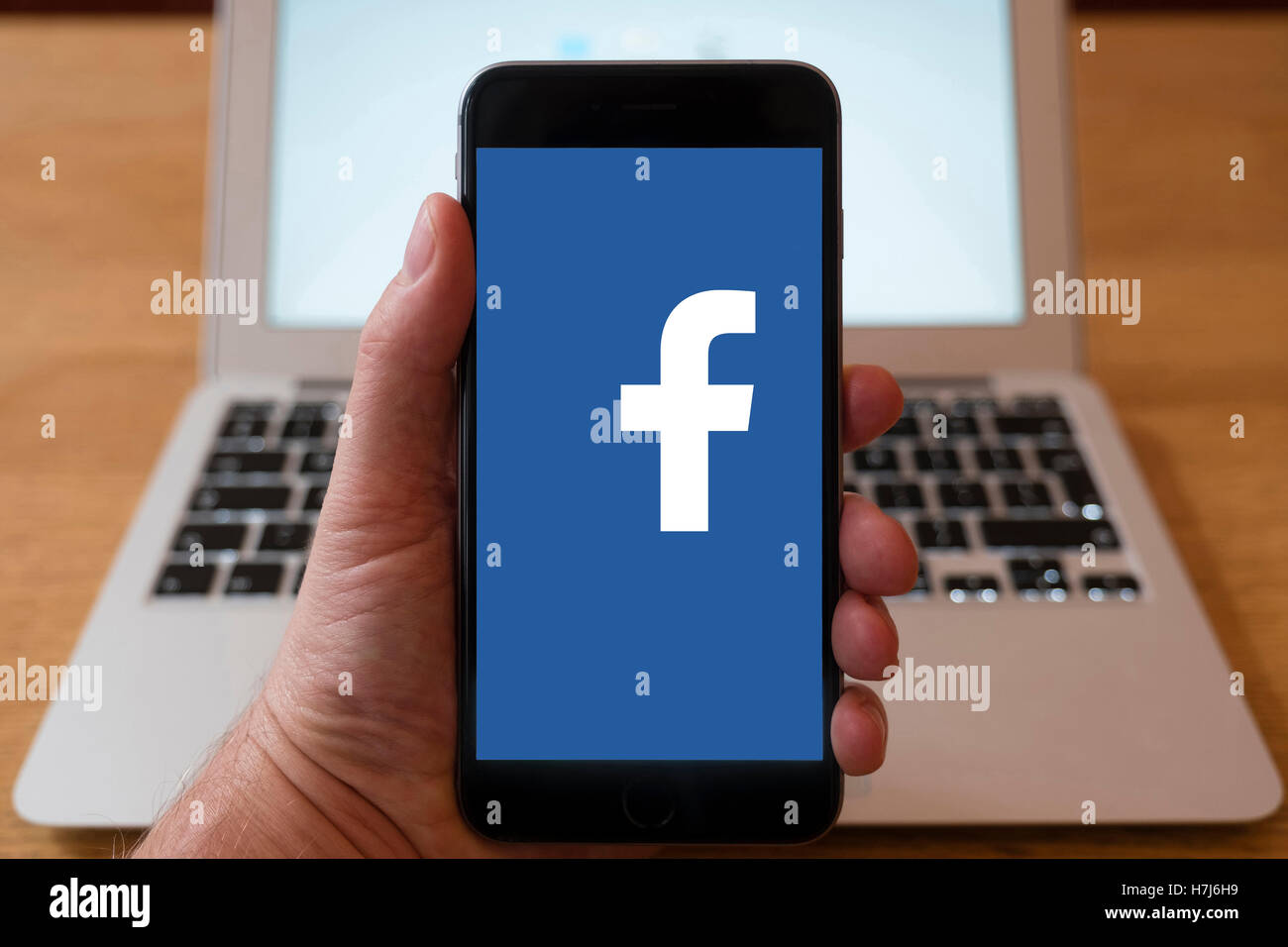 Using iPhone smart phone to display logo of Facebook social media website Stock Photo