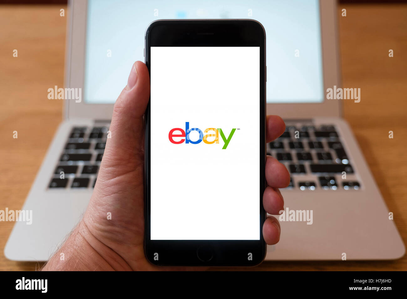 Using iPhone smart phone to display logo of eBay online auction website Stock Photo