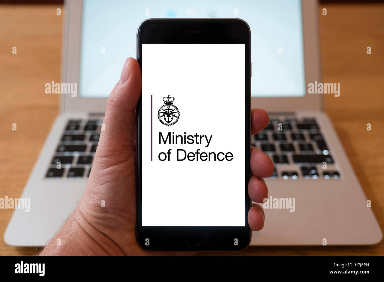 Using iPhone smart phone to display logo of the Ministry of Defence, UK Government Stock Photo
