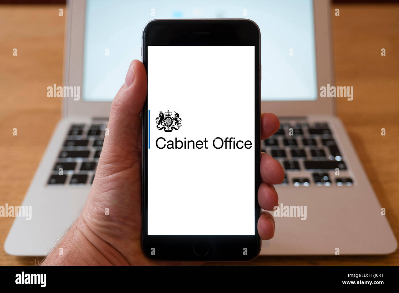 Using iPhone smart phone to display logo of the Cabinet office, UK Government Stock Photo