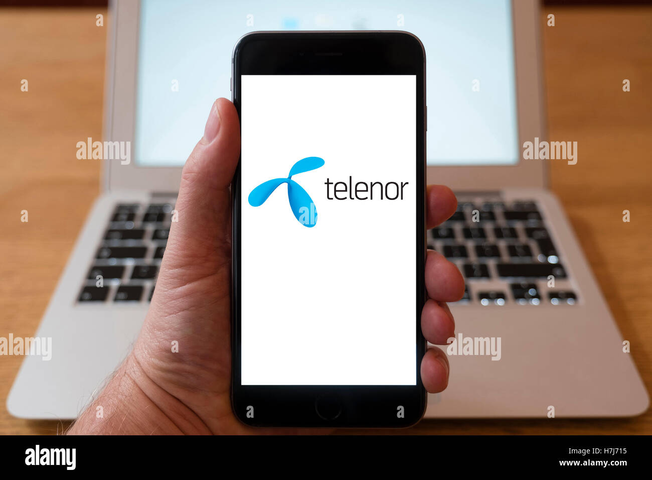 Using iPhone smartphone to display logo of Telenor , Norwegian multinational telecommunications company headquartered Stock Photo