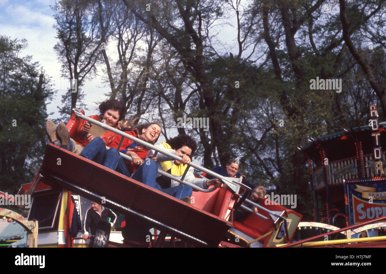 England, 1960s, children riding on an amusement ride, a twist where the passengers sit in small carriages experience centrifugal force. Stock Photo