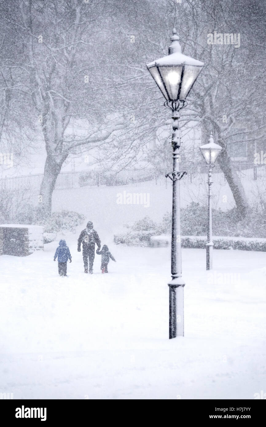 Buxton,Derbyshire in heavy snow. Parent and children in the Pavilion Gardens Stock Photo