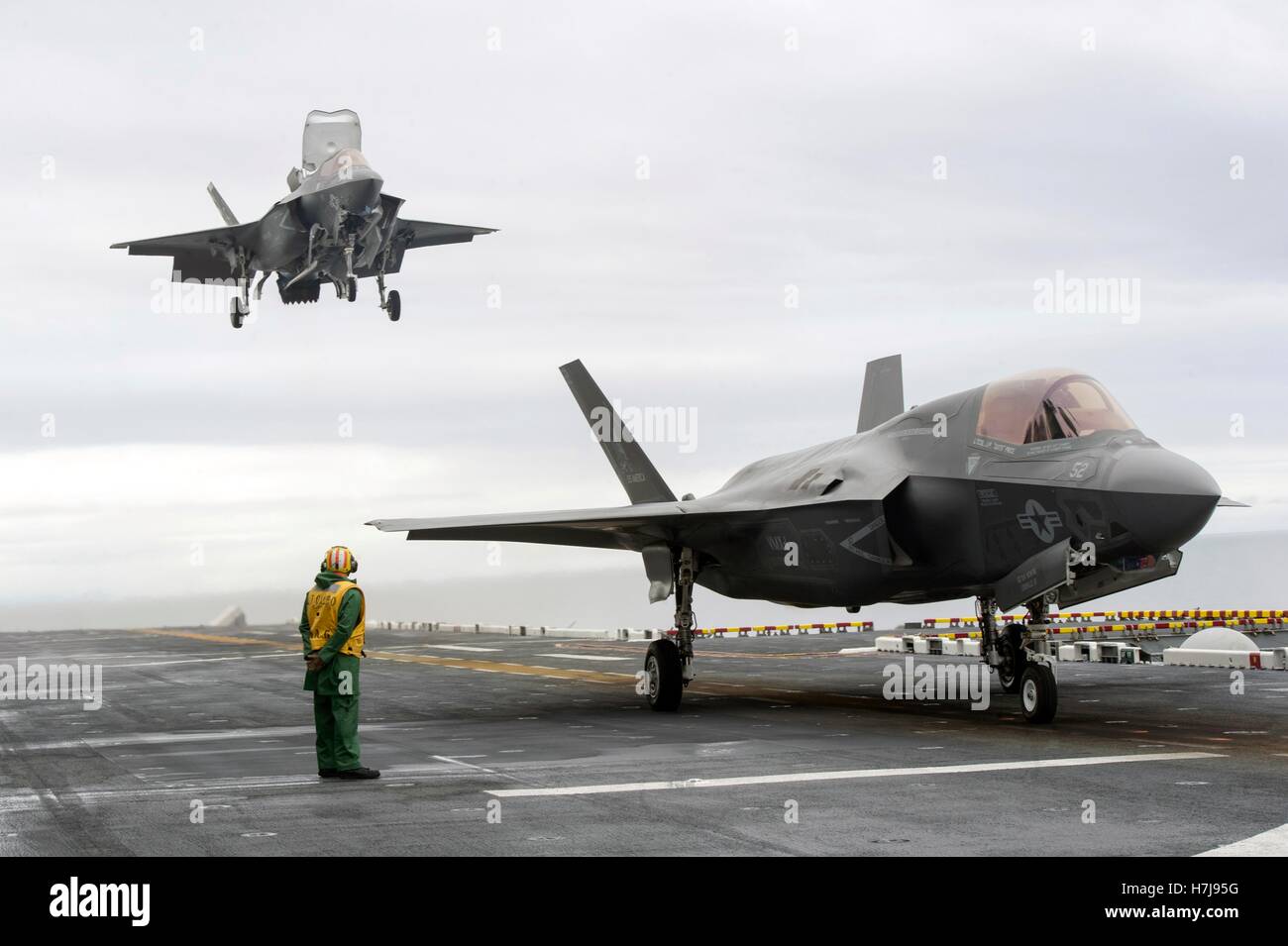 F-35B Lightning II stealth fighter aircraft perform a vertical landing aboard the flight deck of the USN America-class amphibious assault ship USS America October 30, 2016 in the Pacific Ocean. Stock Photo