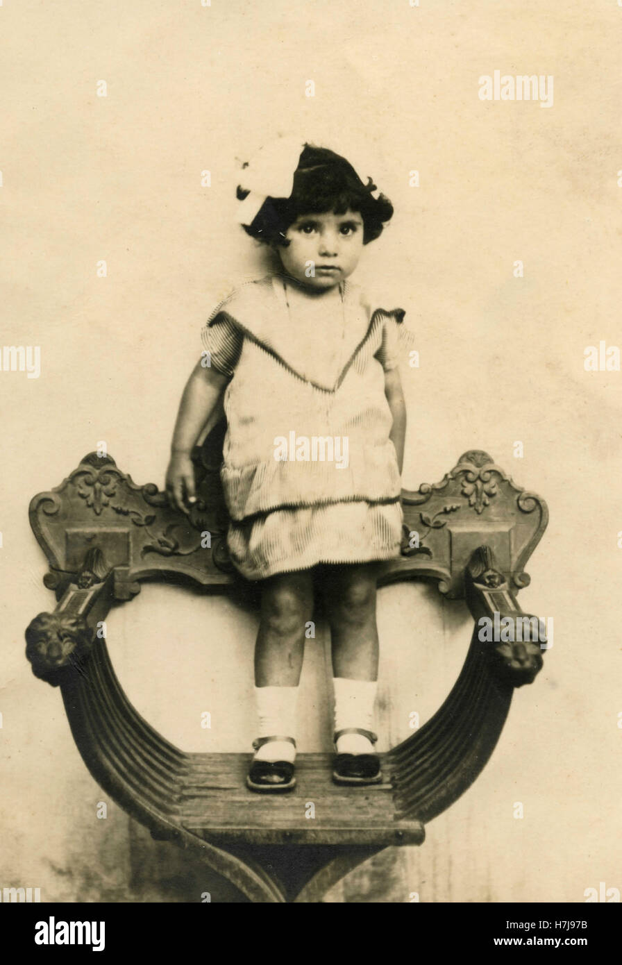 Little girl standing on a chair, Italy Stock Photo