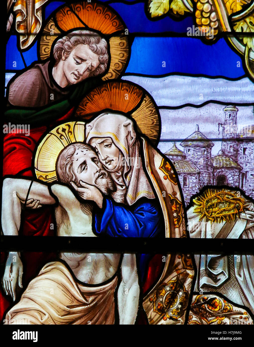 Stained Glass window, depicting Jesus taken from the Cross into Mother Mary's arms, in the Cathedral of Saint Rumboldt in Mechel Stock Photo