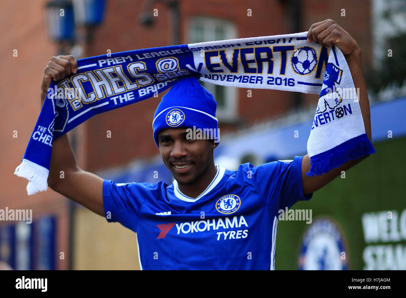 A Chelsea fan holds up a half and half scarf prior to kick off during