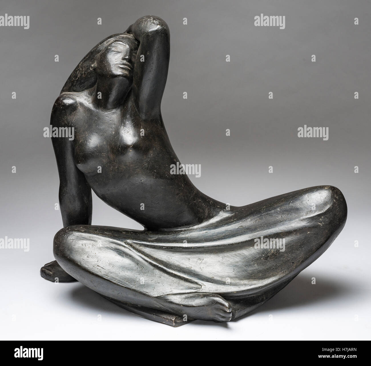 Sitting young girl, patinated plaster sculpture by French sculptor Jean Henninger Stock Photo