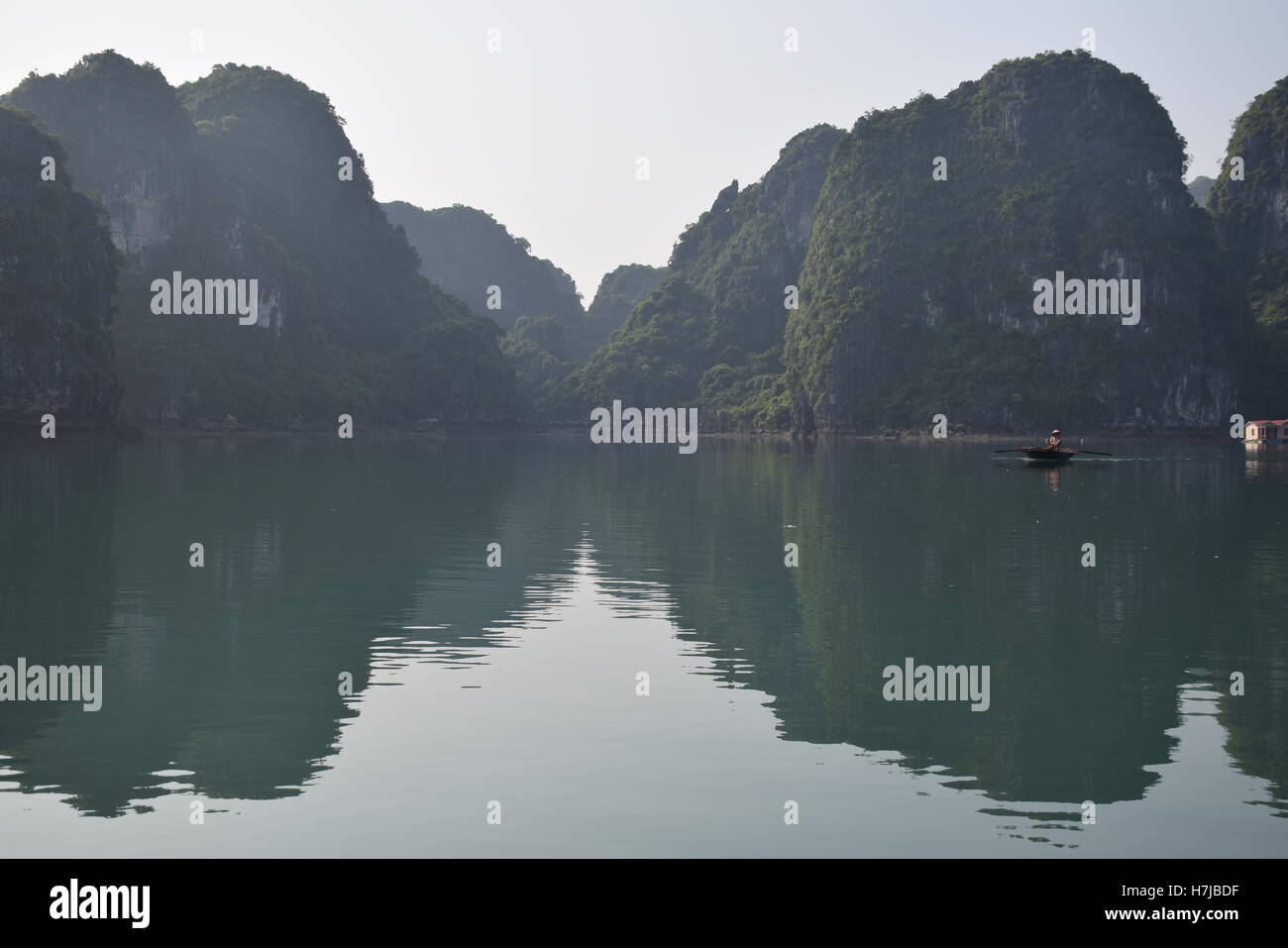 Mountains and boat inside a floating village in Halong bay, Vietnam Stock Photo