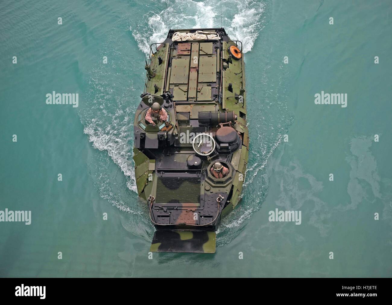 An aerial view of U.S. Marine soldiers as they maneuver an amphibious assault vehicle into the well deck of the USN Whidbey Island-class amphibious dock landing ship USS Ashland August 15, 2015 in Apra Harbor, Guam. Stock Photo