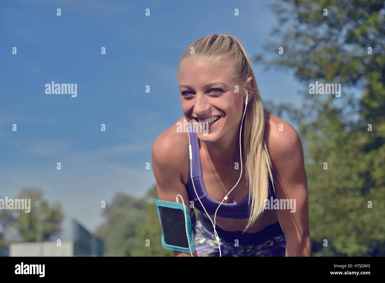 Young woman taking rest after jogging workout at the park Stock Photo