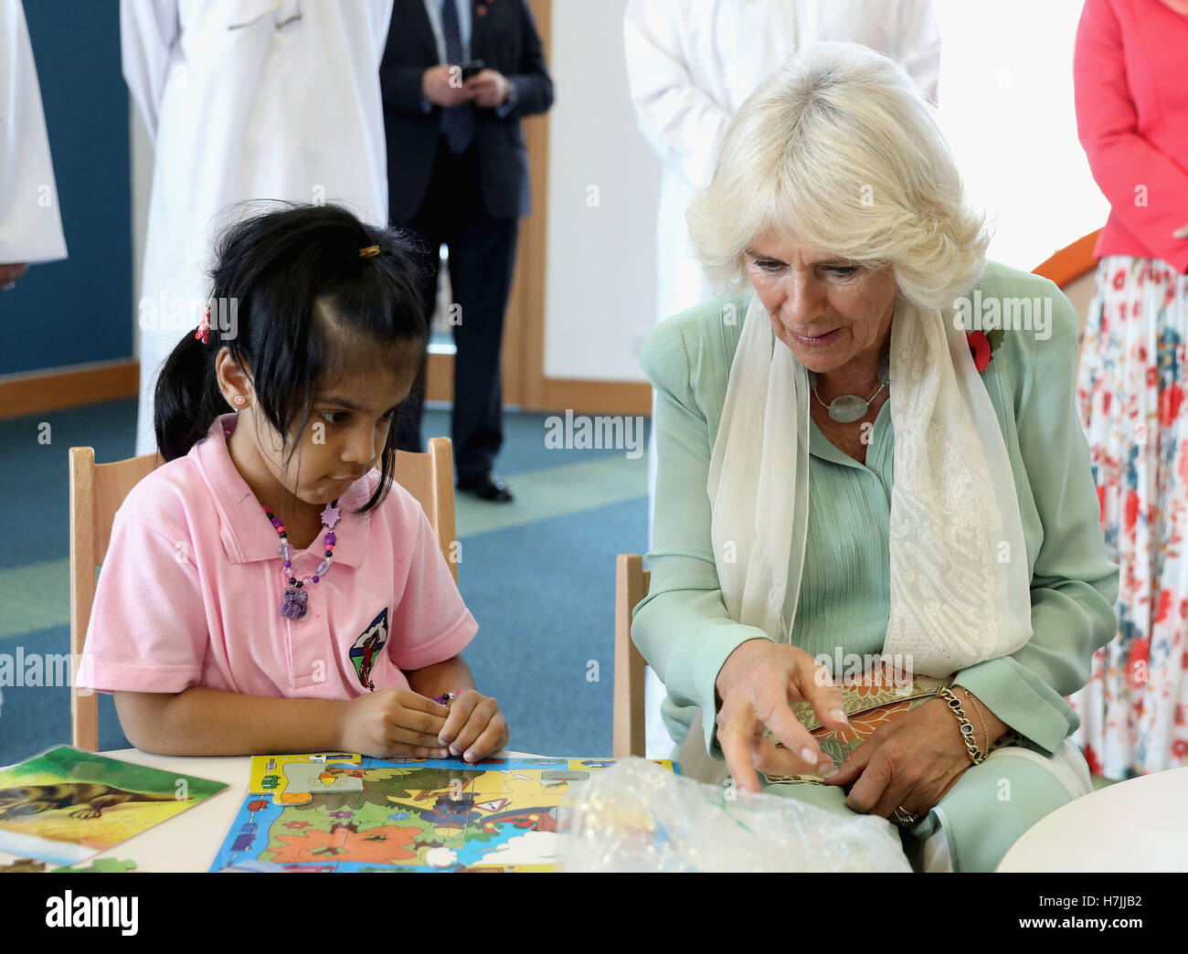 The Duchess of Cornwall completes a puzzle with a young girl as she ...