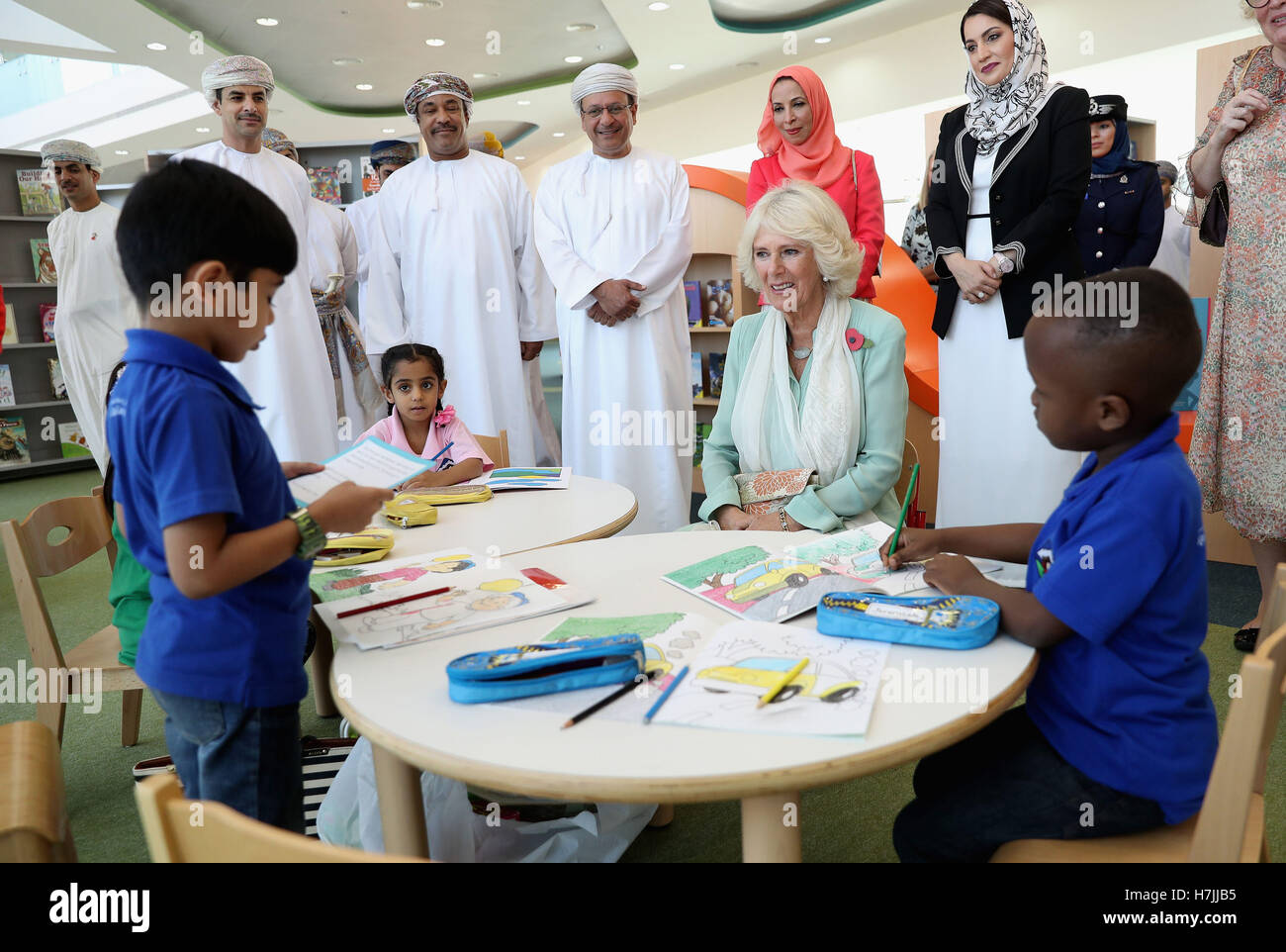The Duchess of Cornwall (seated) listens to a young boy reading as she ...