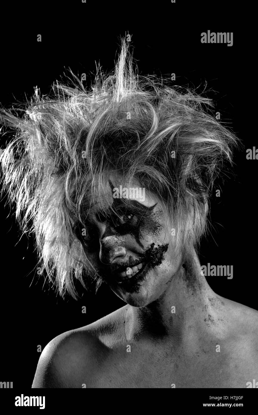 Blonde female model as bloodstained, crazed, insane, murderous clown, black and white, monochrome Stock Photo