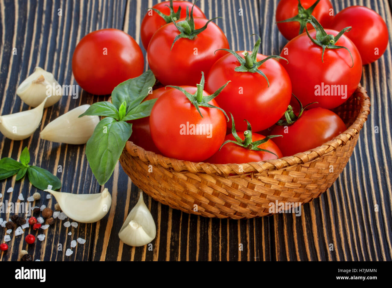 cherry tomatoes, garlic and basil over wooden table background Stock ...