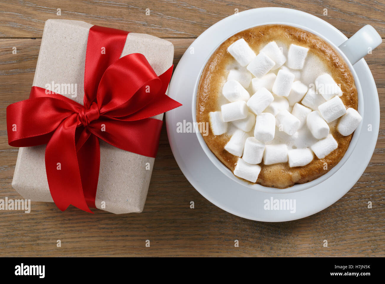 cup of cappuccino with marshmallow zand gift box on table Stock Photo