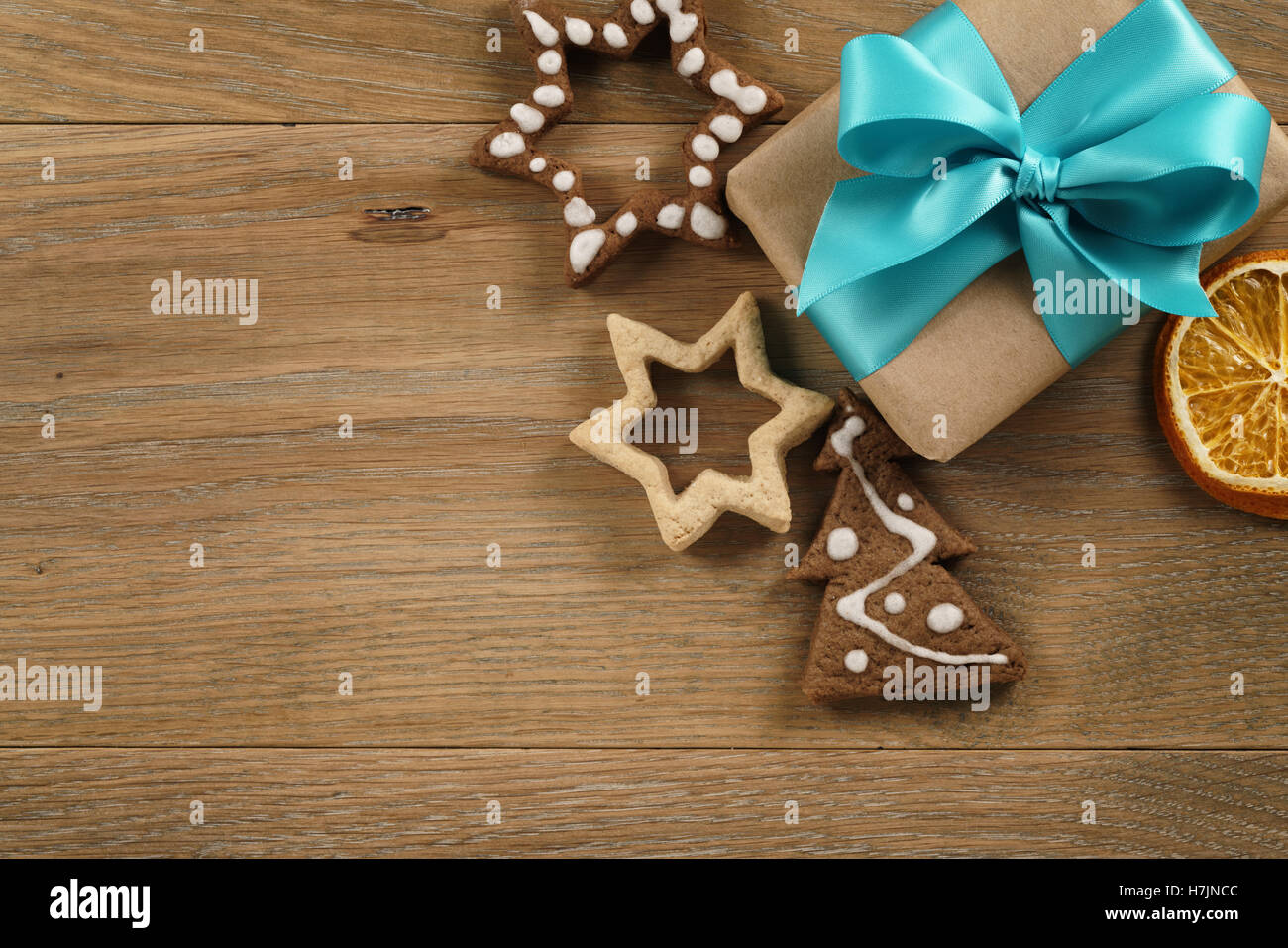 gift box with azure ribbon bow and christmas cookies on wood table Stock Photo