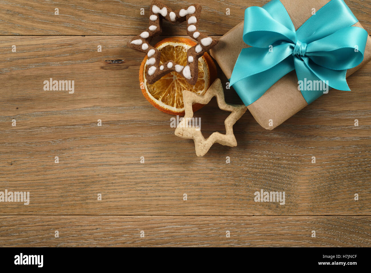 gift box with azure ribbon bow and christmas cookies on wood table Stock Photo