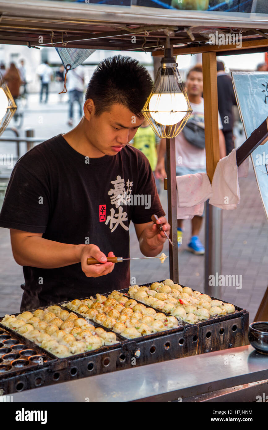 Unidentified man preparing food on the street of Osaka, Japan. Stock Photo