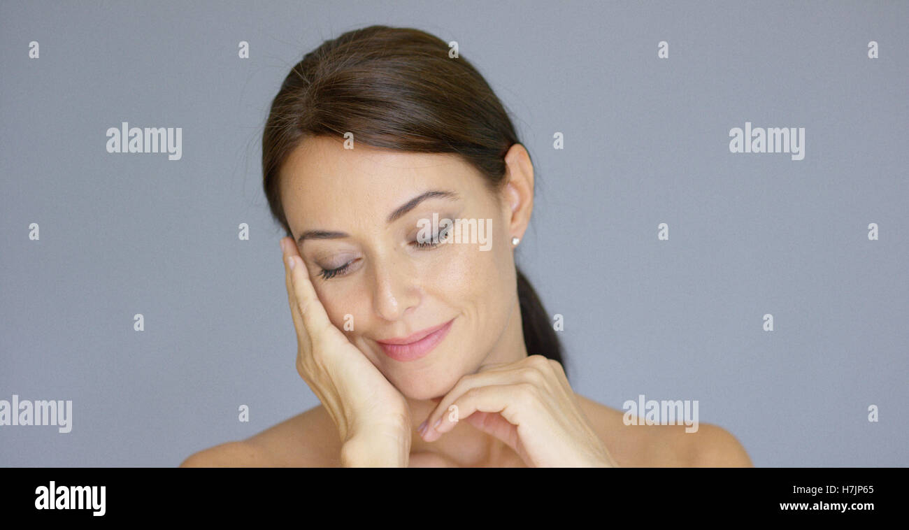 Single young woman in brown hair with hand on face Stock Photo - Alamy