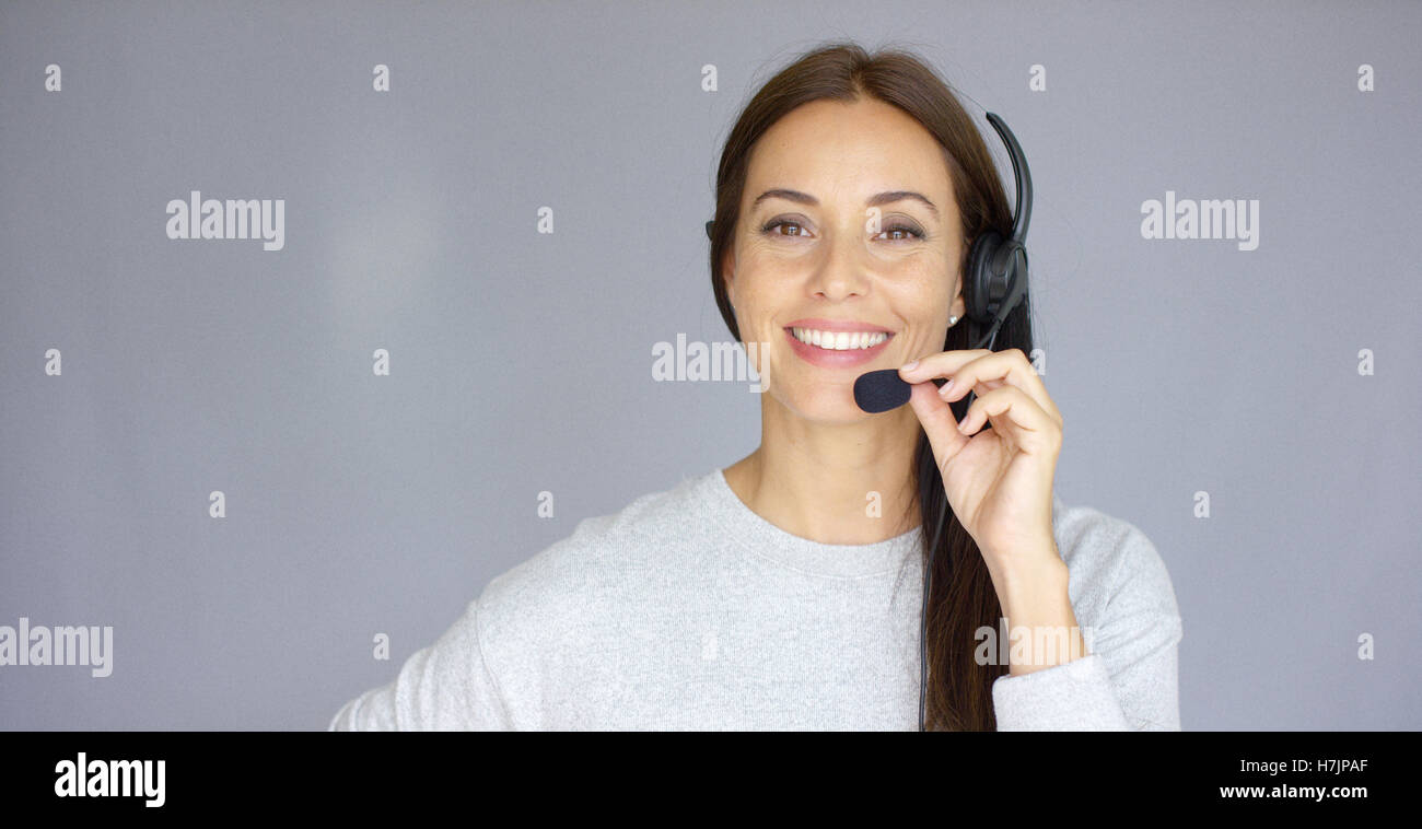 Adorable call center agent speaking with someone on headset Stock Photo