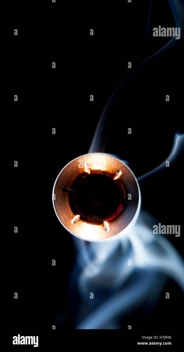 Copper jacketed hollow point coming at the camera with smoke Stock