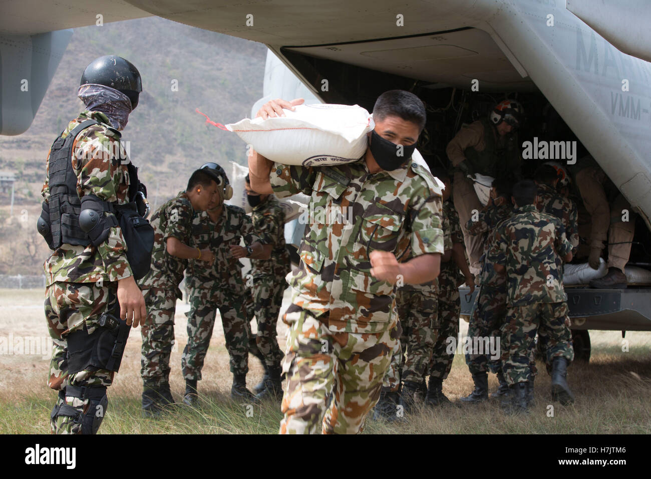U.S. and Nepalese soldiers unload supplies from an MV-22 Osprey helicopter during a humanitarian assistance and disaster relief mission following a major earthquake May 8, 2015 in Manthali, Ramerhab District, Nepal. Stock Photo