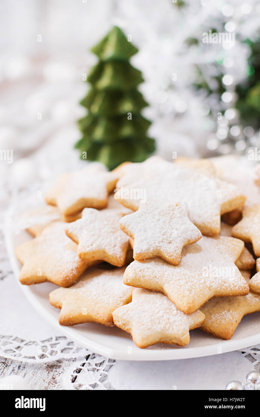 Christmas cookies and tinsel on a light wooden background. Stock Photo