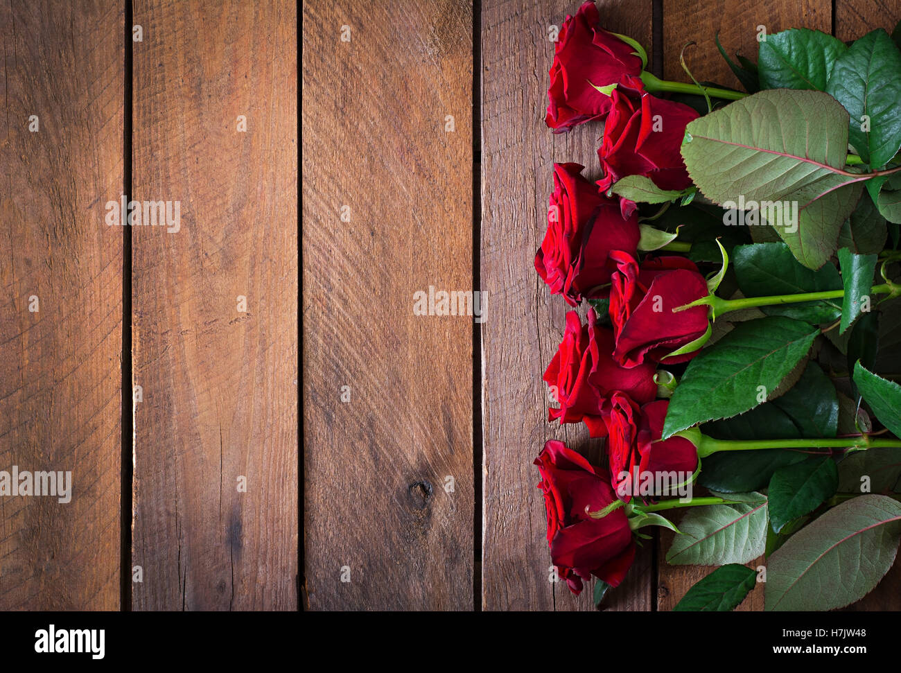 Bouquet of red roses on a dark wooden background. Top view Stock Photo ...