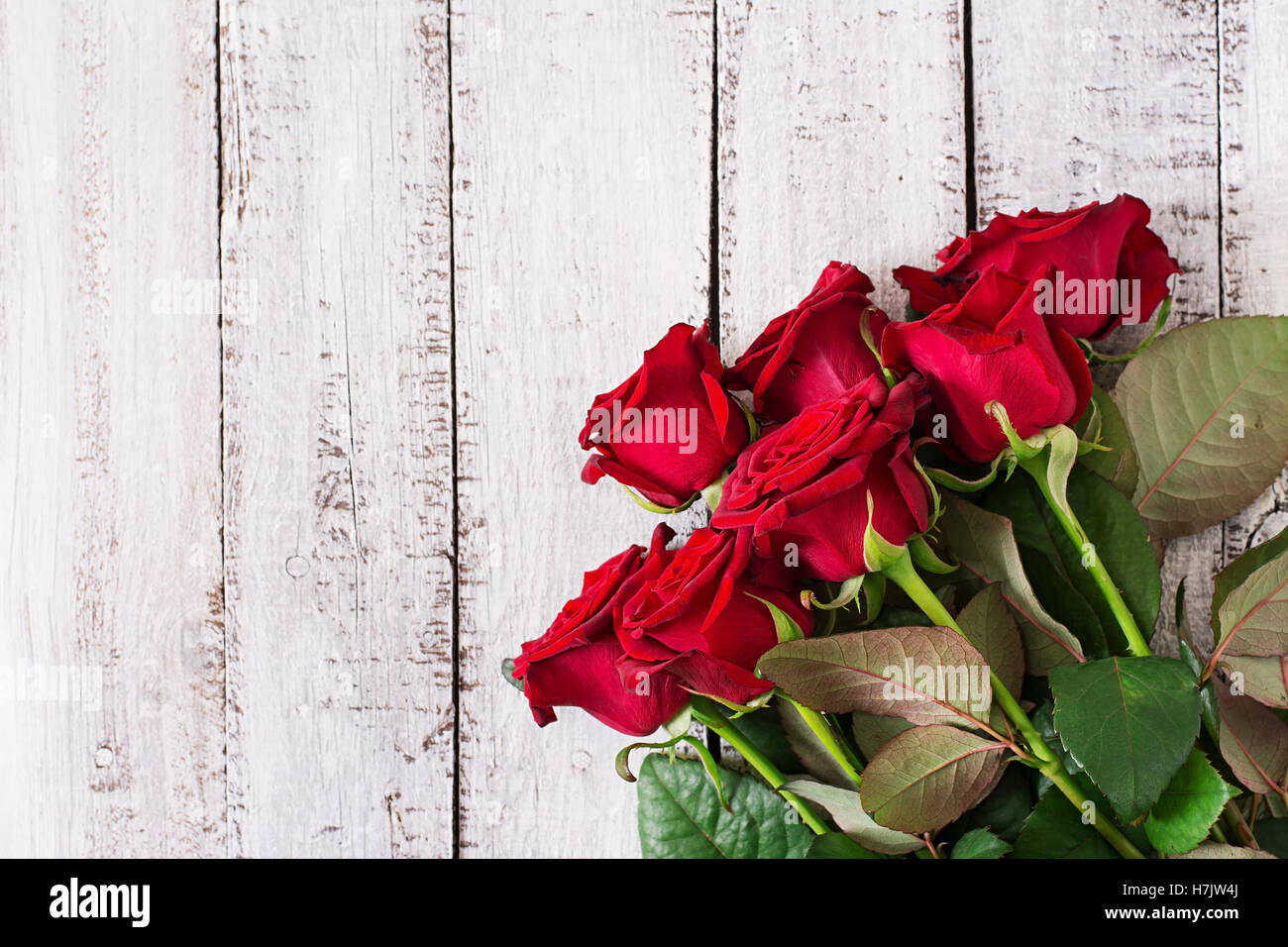 Bouquet of red roses on a light wooden background. Top view Stock Photo ...