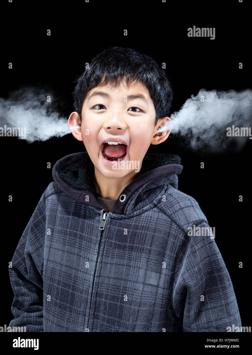 Asian boy letting off steam as he expresses his emotions. Concept of stress, anger, frustration and extreme emotions. Stock Photo