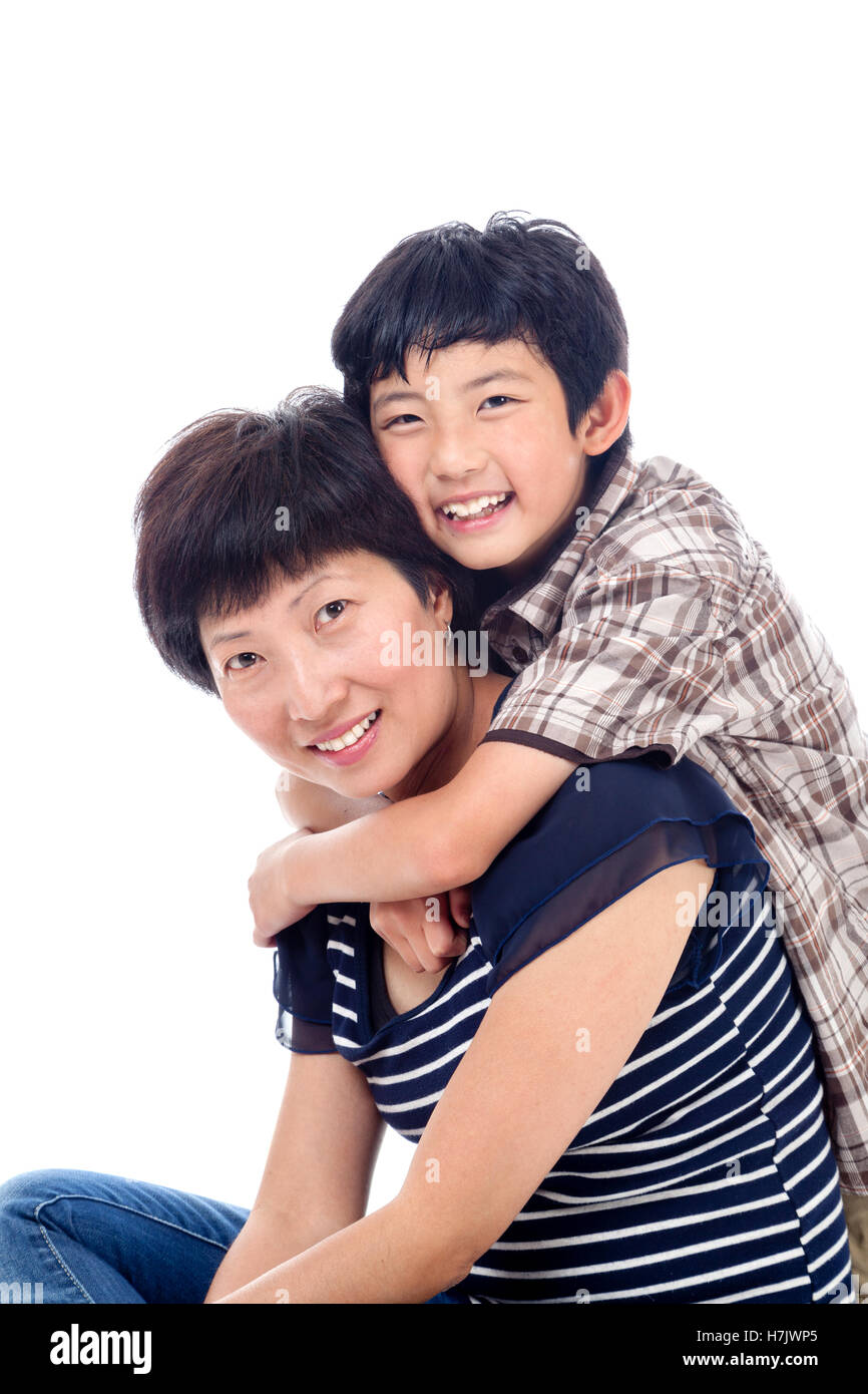 Asian boy hugs mom in affectionate pose. Stock Photo