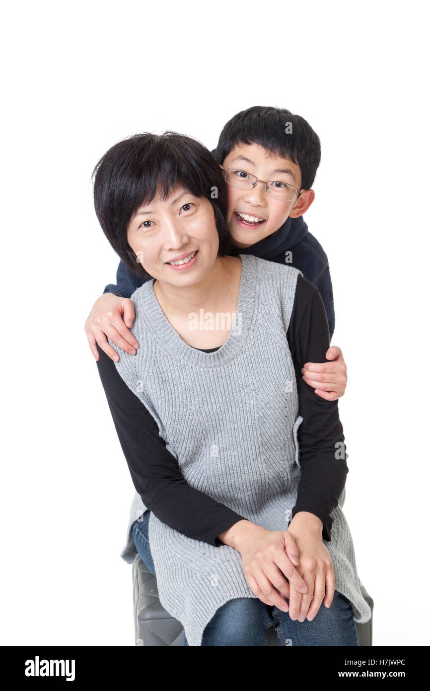 Affectionate little Asian boy and his mother in a happy pose. Isolated on white background. Stock Photo