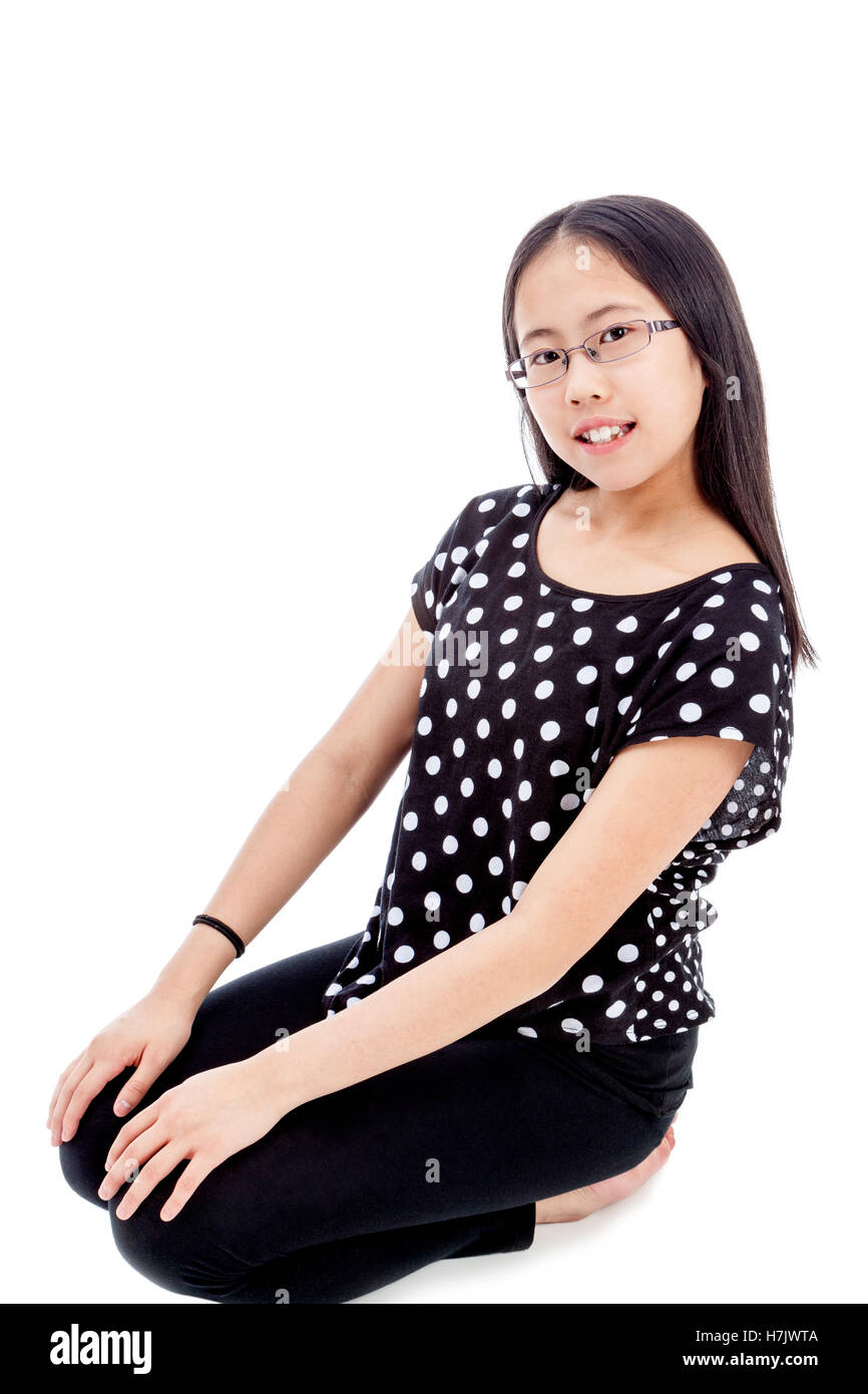 Asian tween girl in a kneeling pose, isolated on white background Stock Photo