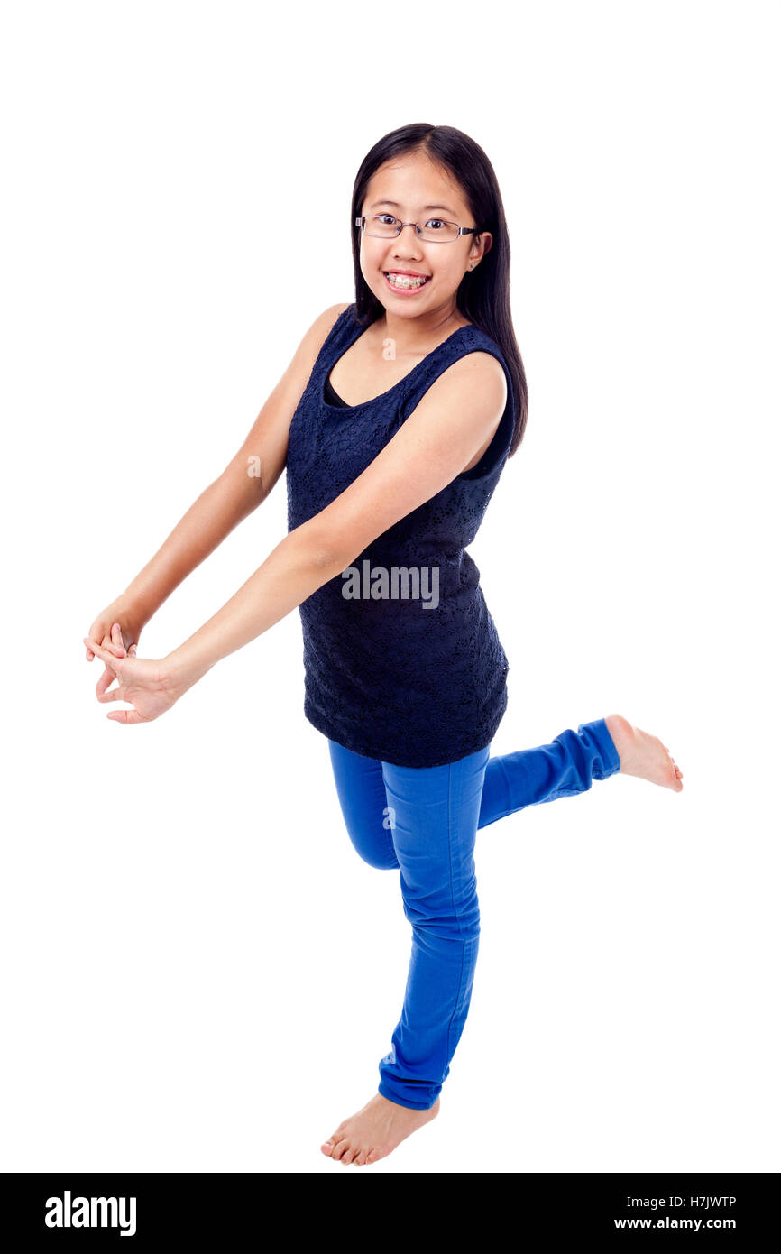 Cute Asian girl in braces striking a confident pose, isolated on white. Stock Photo