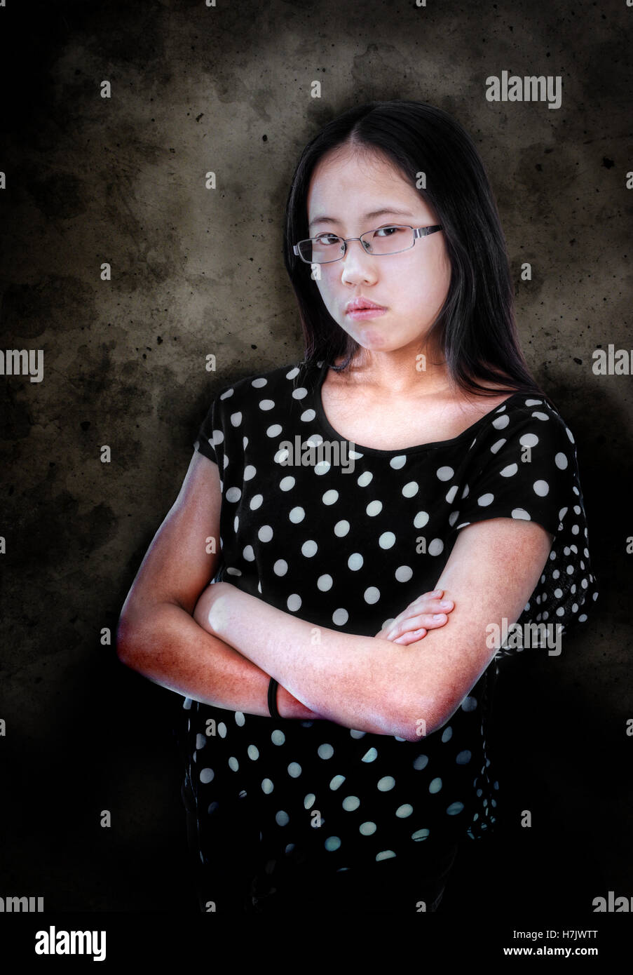 Asian tween girl with folded arms showing displeasure Stock Photo