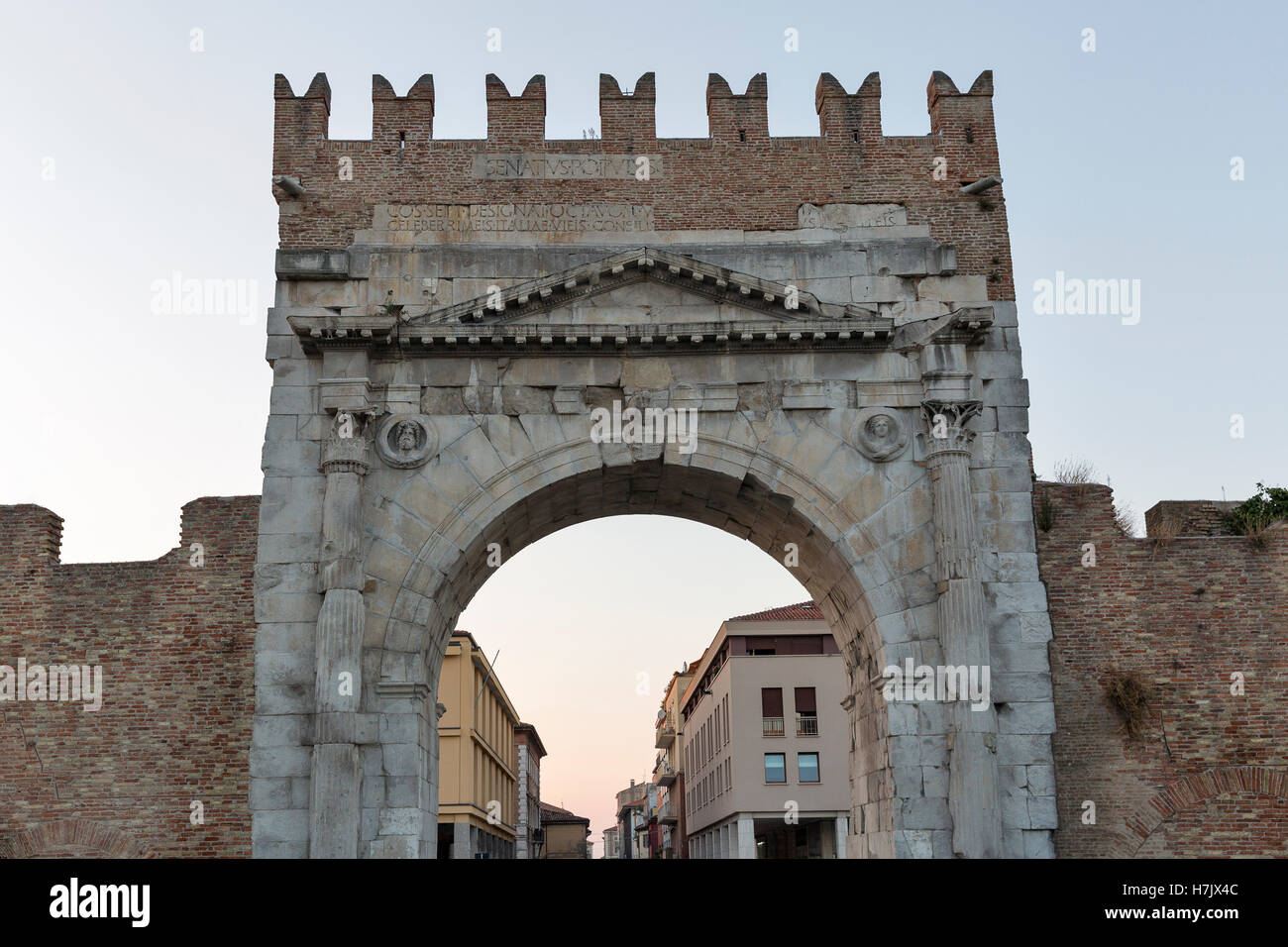 Arch of Augustus at sunset in Rimini, Italy. Ancient romanesque gate of the city - historical landmark, the most ancient roman a Stock Photo
