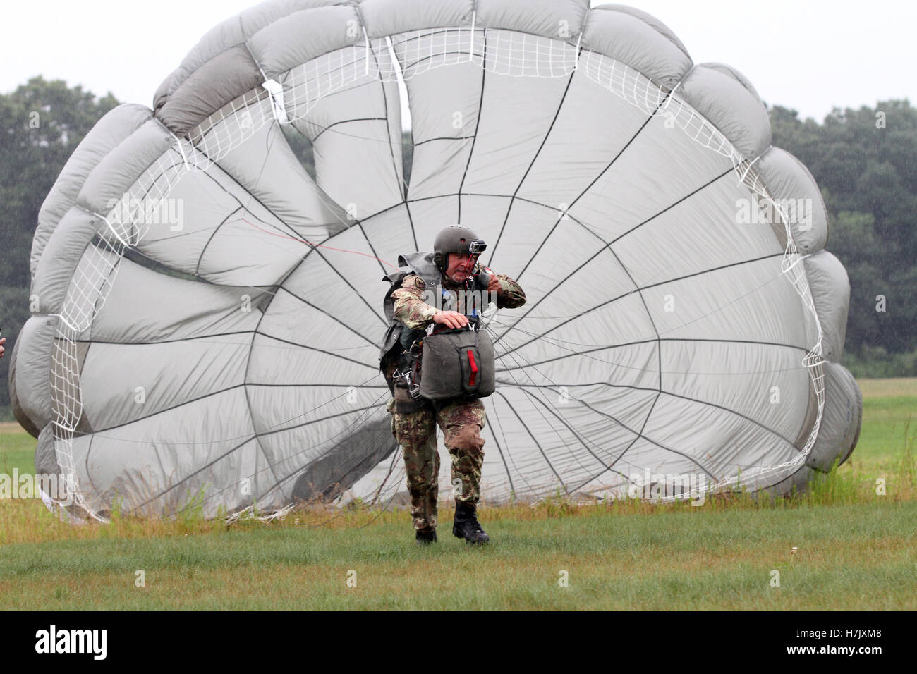 An Italian paratrooper soldier pulls his inflated parachute canopy while running to an X on the Drop Zone during the Leapfest-International Airborne Competition August 2, 2014 in West Kingston, Rhode Island. Stock Photo