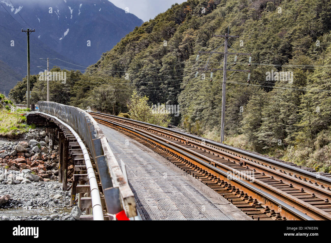 Arthur's Pass, New Zealand: The railway makes its way through the sub-alpine terrain, crossing a river on an old wooden bridge. Stock Photo